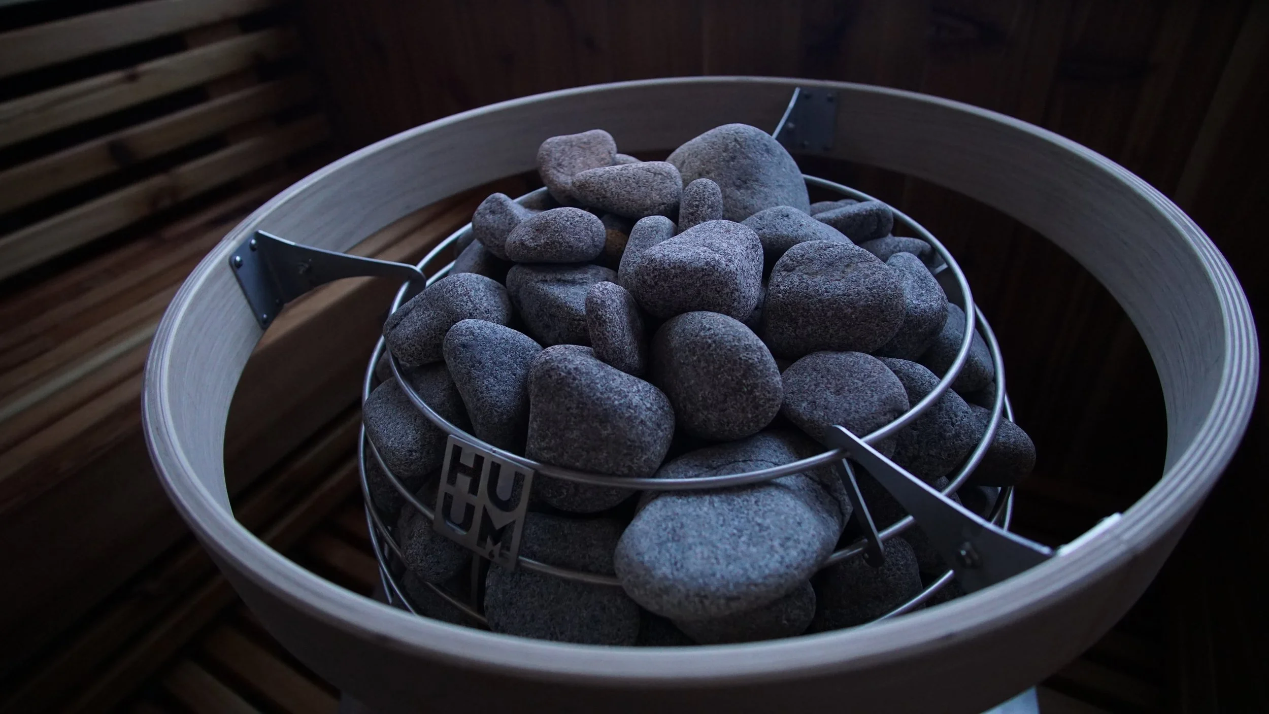 Huum sauna heater basket stacked with rounded stones